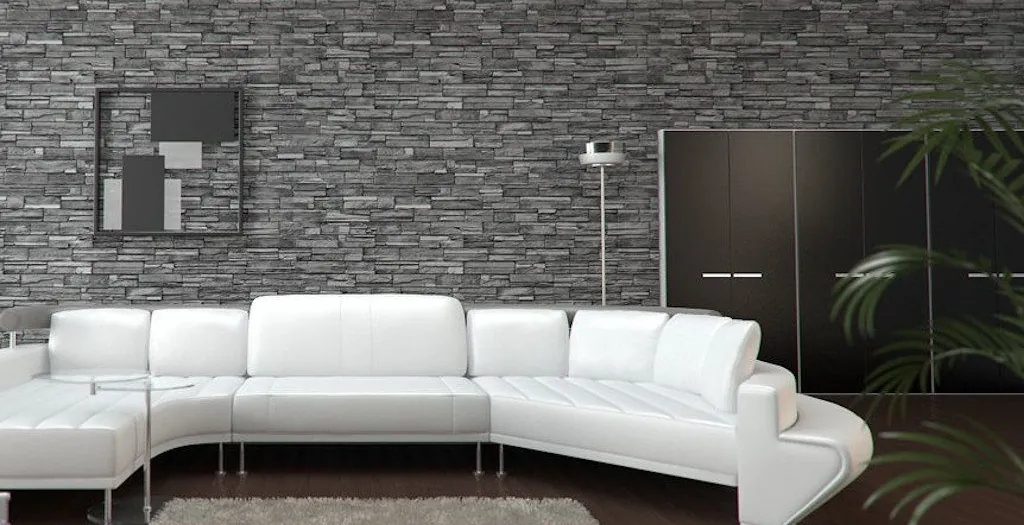Woonkamer met een wand van grijze Crobrick steenstrips achter een witte bank